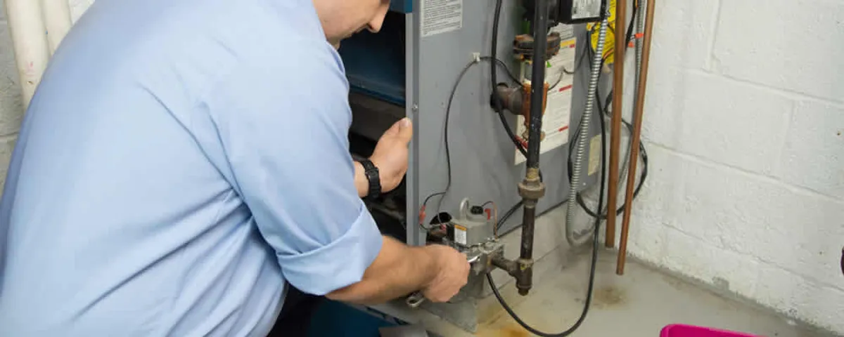 Furnace repair technician inspecting and servicing a home heating system in Tacoma, WA
