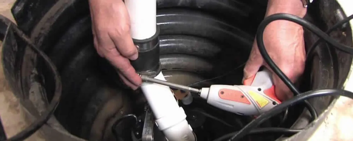 Sump pump installation technician connecting PVC discharge piping in Tacoma, WA